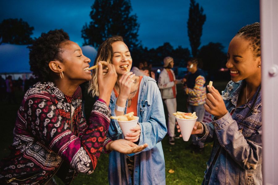People enjoying food together at an outdoor evening gathering.