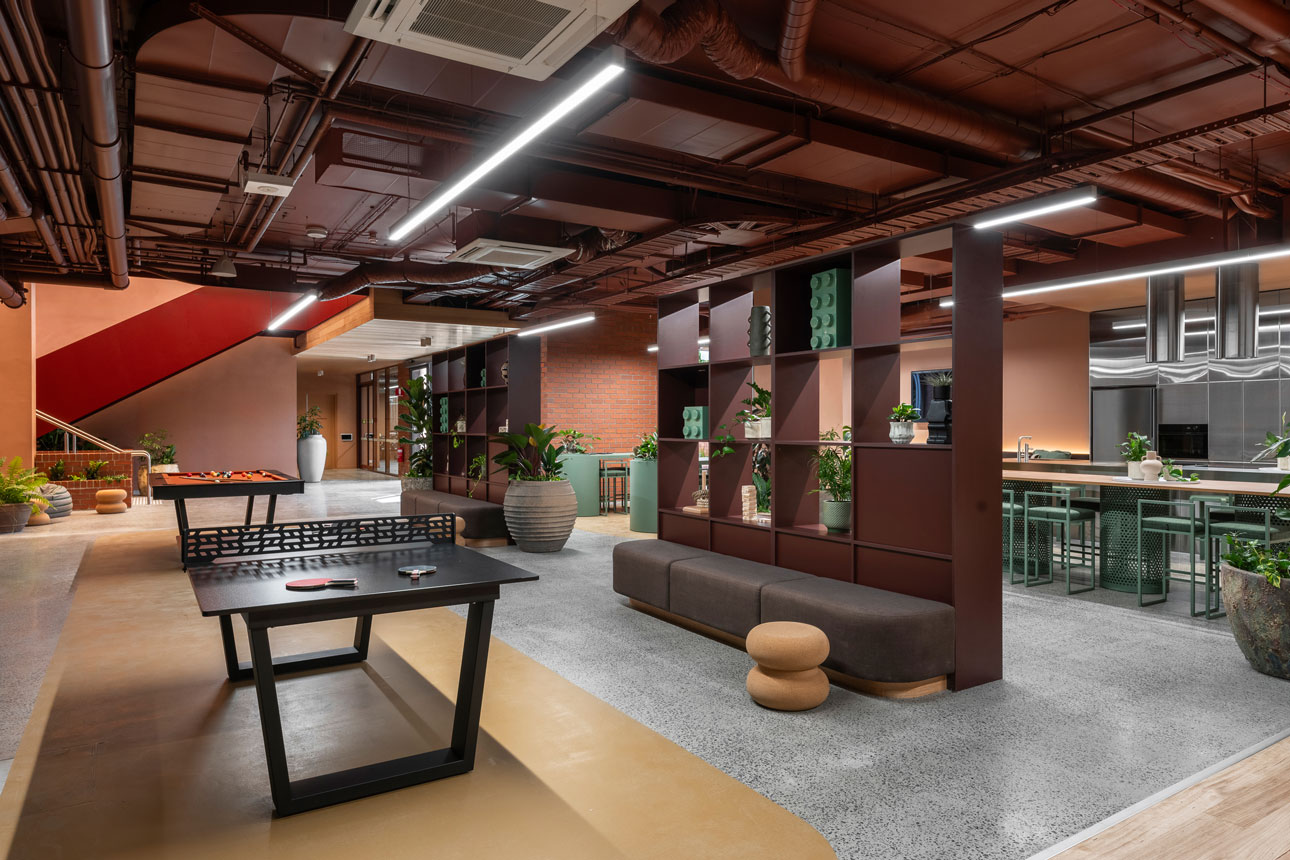 Modern lounge area with stylish furniture, plants, and open shelving.