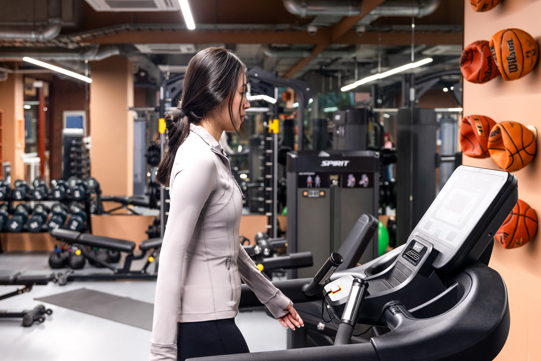Person walking on treadmill in gym.