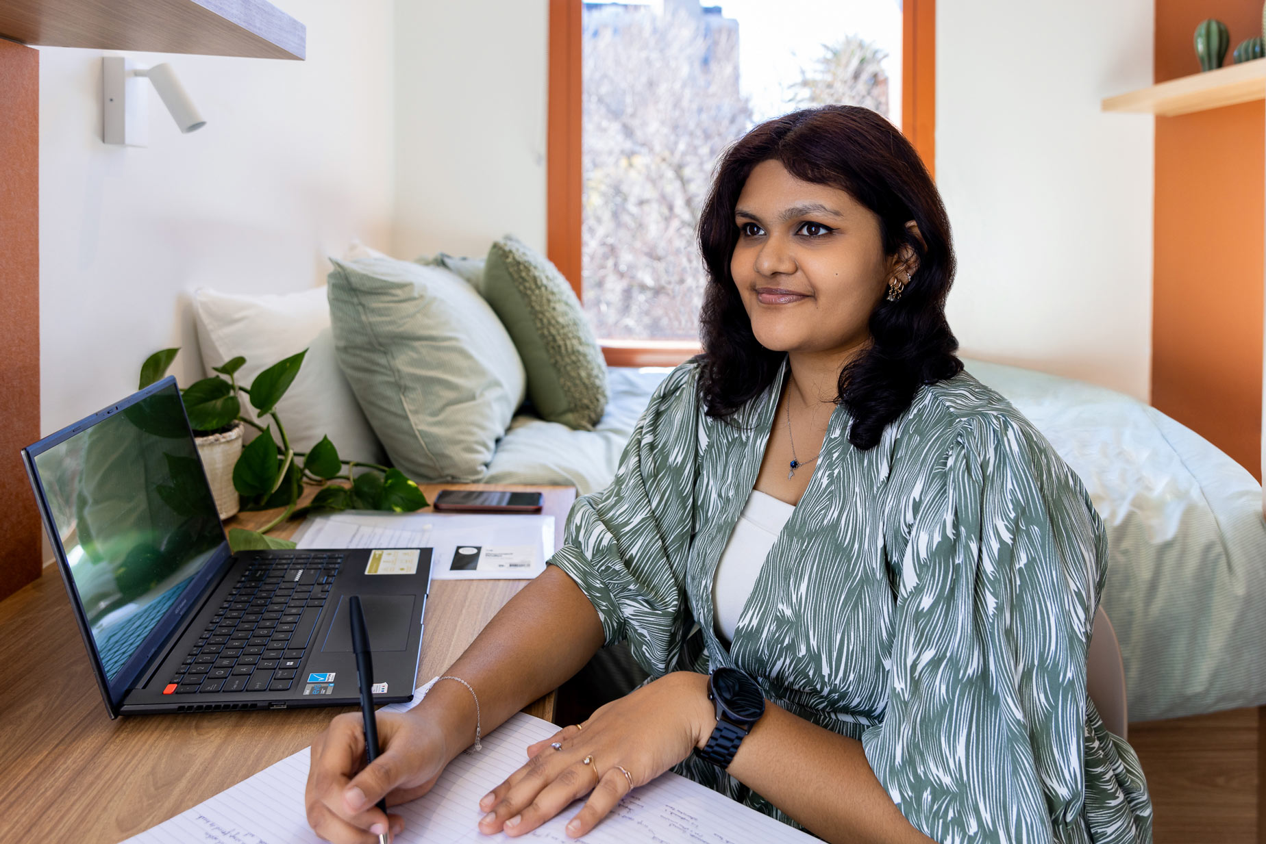 Person studying at desk near window.